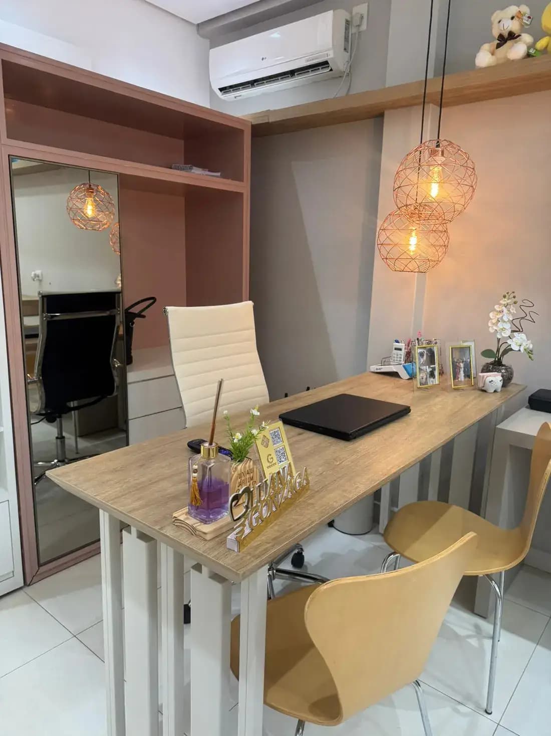 Sala de consulta do consultório, com mesa, cadeiras e prateleiras