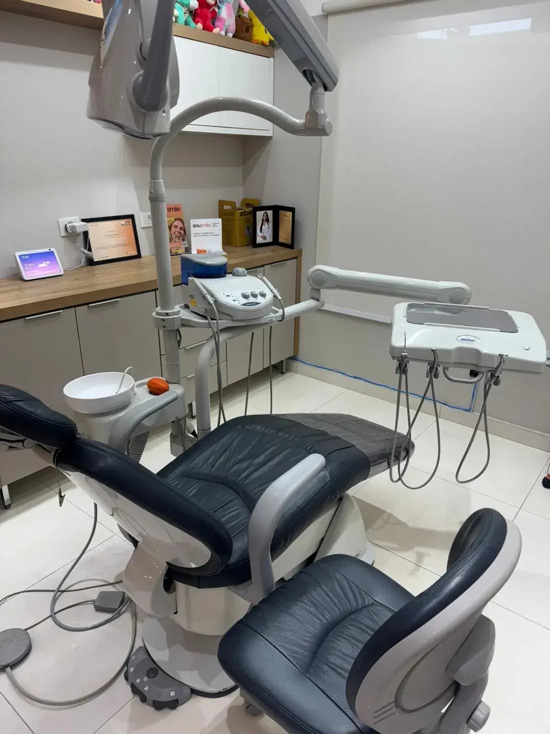 Sala de atendimento do consultório, com cadeira odontológica e bancada